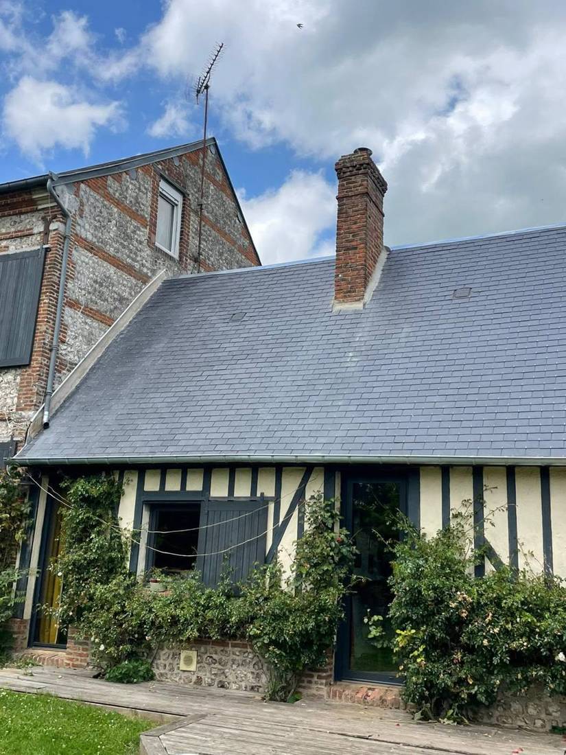 Maison à colombages couverte d'ardoises, pignon en brique et silex