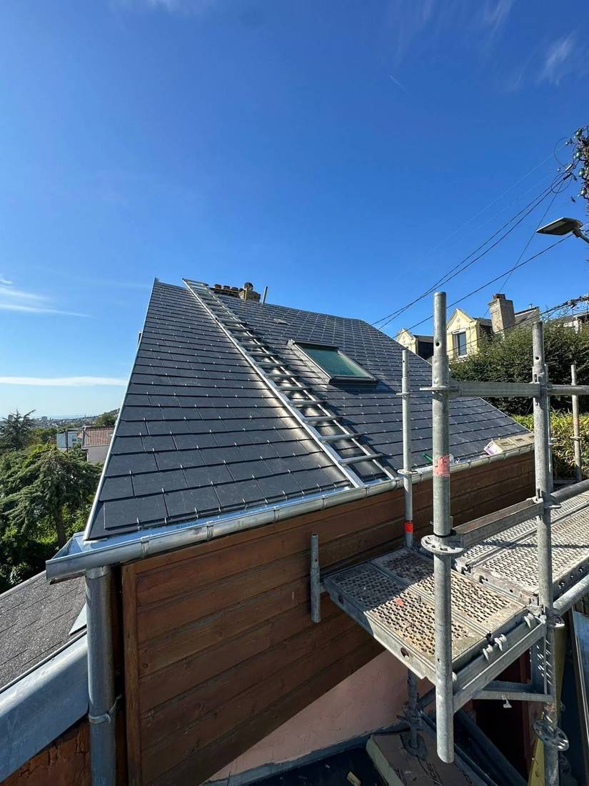 Couverture en ardoise avec fenêtres de toit, échafaudage monté en bord de toit