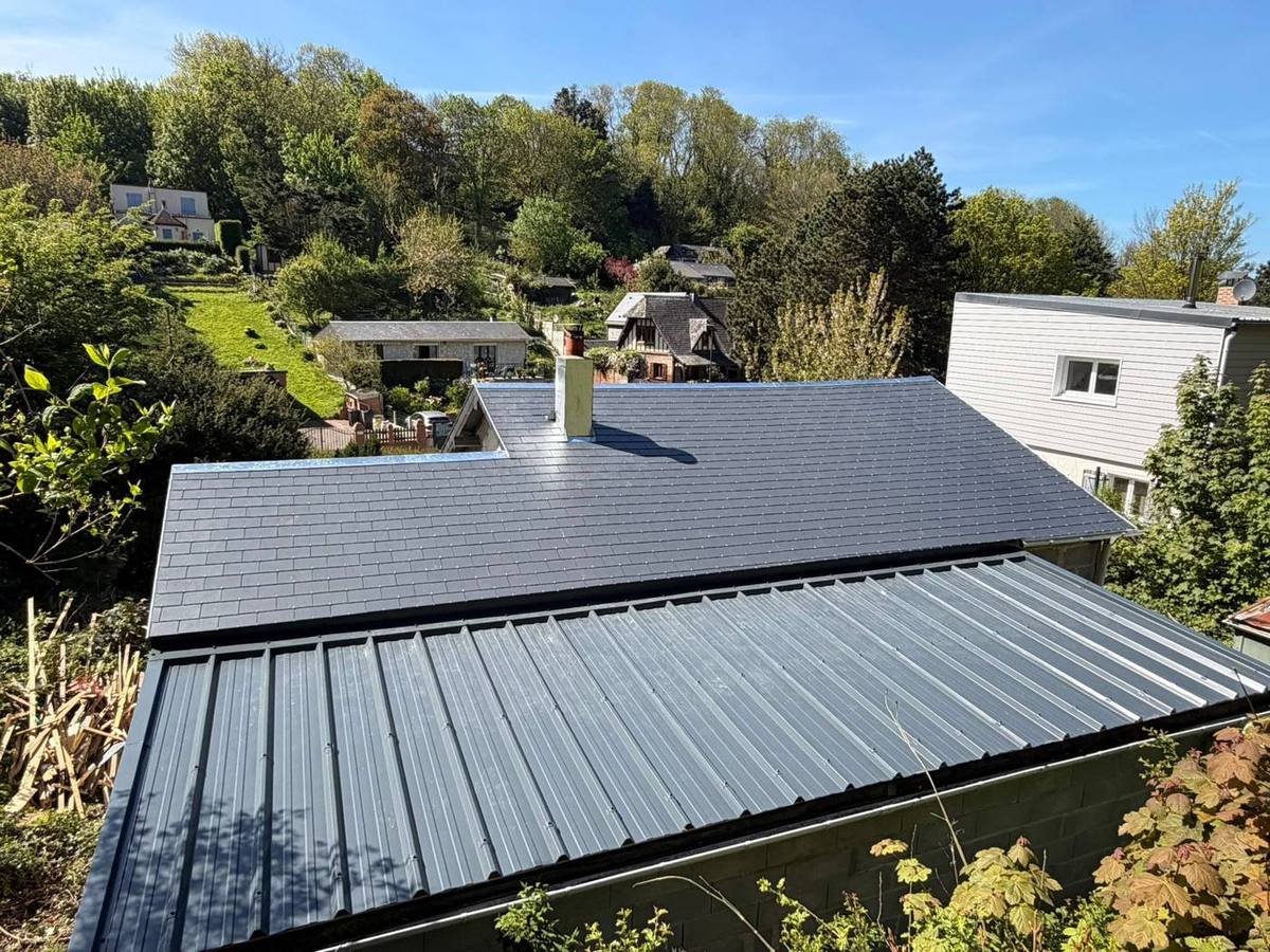 Maison couverte en ardoise avec une extension en bac acier