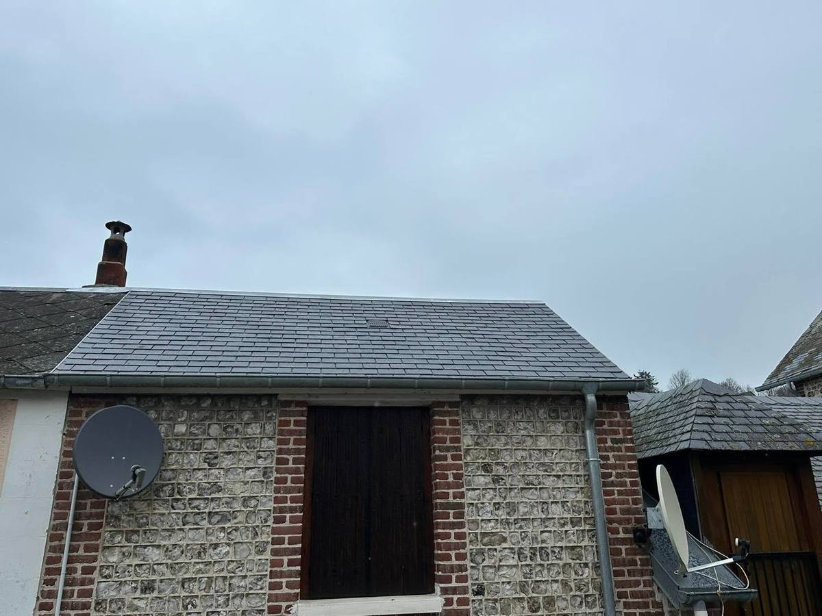 Toiture en ardoise sur une maison en silex et brique