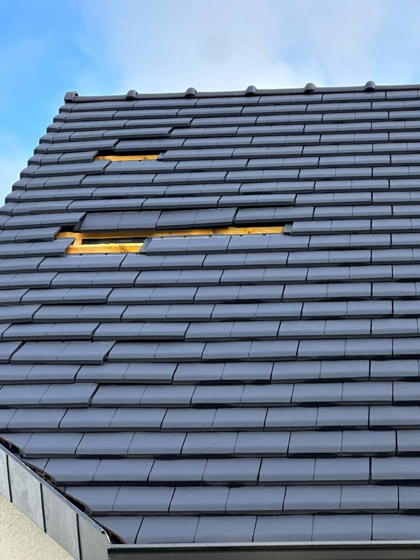 Tuiles arrachées par le vent sur un pan de toiture, voliges apparentes