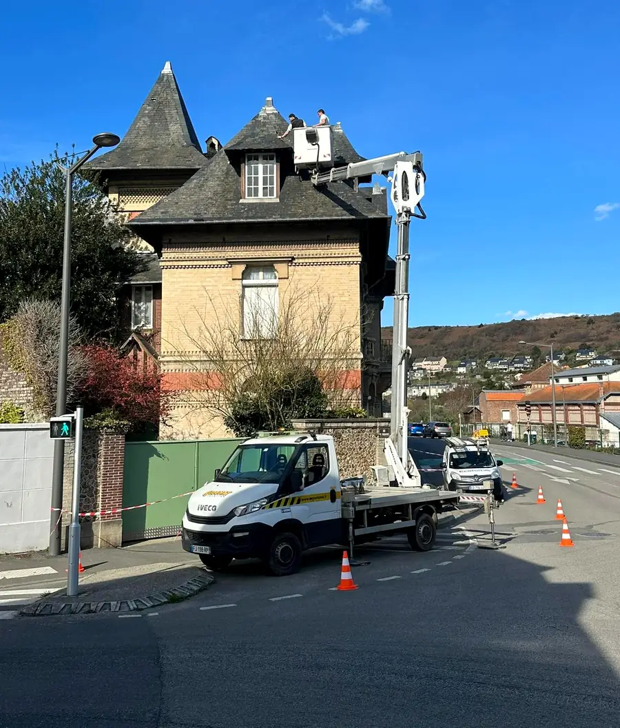 Camion nacelle Eco Toit devant une maison de maître, prêt pour une intervention en hauteur